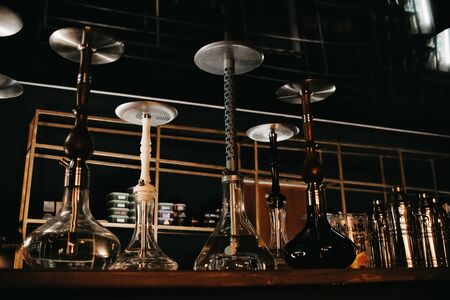 many hookahs with shisha glass flasks and metal bowlsの写真素材