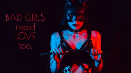 girl in a BDSM costume and a hare mask with a whip on a black backgroundの写真素材