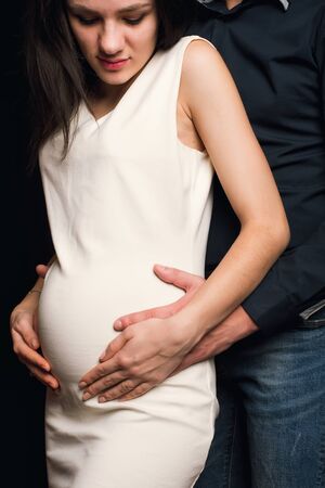 man hugs the belly of a pregnant girl. Couple is expecting a baby