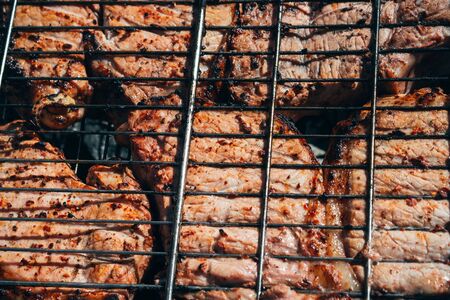 pork meat is cooked on coals of the fire on grill barbecue