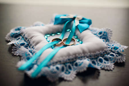 gold wedding rings on the pillow with lace