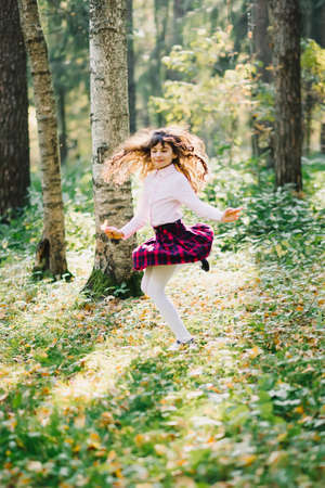 happy beautiful brunette girl is spinning and enjoying herself in the Parkの写真素材