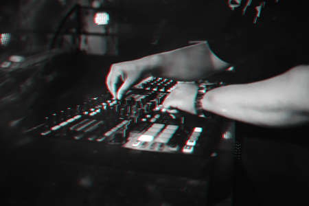 DJ plays on music mixer in a nightclubの写真素材