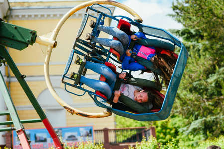 VICHUGA, RUSSIA - JUNE 24, 2017: Two girls ride a carousel in the Park on the Day of Vichuga
