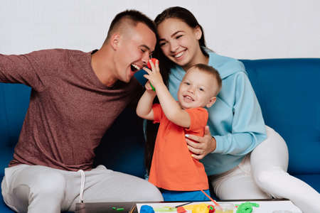 happy white family enjoy and play at home. Mom, dad and son laughの写真素材
