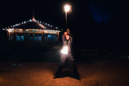 SEMIGORYE, IVANOVO OBLAST, RUSSIA - JULY 16, 2016: Dangerous fire show from the team of professional performers with burning torchesのeditorial素材