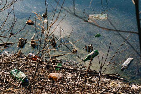 VICHUGA, RUSSIA - APRIL 21, 2019: Plastic and glass bottles on the river Bankのeditorial素材