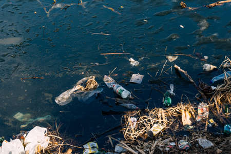 VICHUGA, RUSSIA - APRIL 21, 2019: Various garbage and rubbish from plastic bottles and bags in the water and on the river shoreのeditorial素材