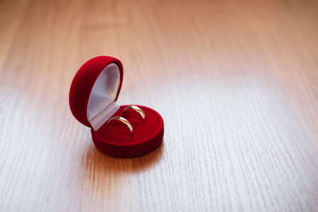 pair of gold wedding rings lie in a red boxの写真素材