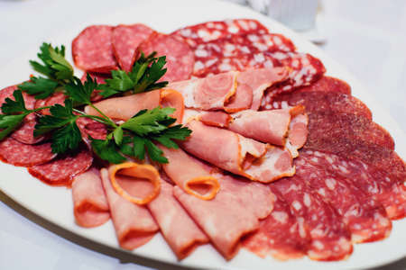 slices of ham and sausage on a plate for a snack