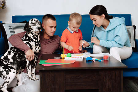 young Caucasian family with a dog do creative work at homeの写真素材