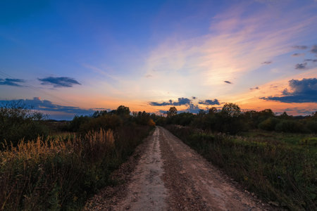 evening landscape with sunset over the road in autumnの写真素材