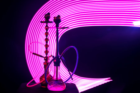 two hookahs with shisha coals pink neon lighting