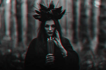 black terrible witch holds candles in her handsの写真素材