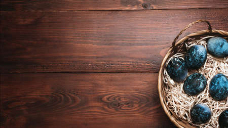 blue Easter eggs in a basket on a wooden backgroundの写真素材