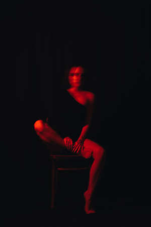 blurry portrait of a girl with mental disorders sitting on a chairの写真素材