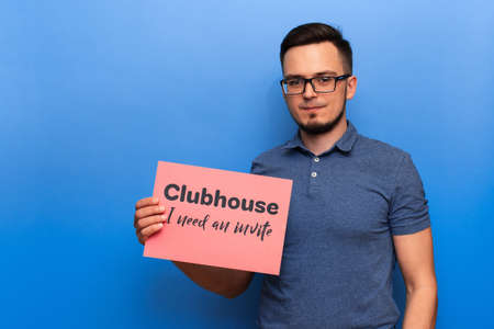 VICHUGA, RUSSIA - FEBRUARY 20, 2021: man holds a banner with a request to invite him to the trending Clubhouse appの写真素材