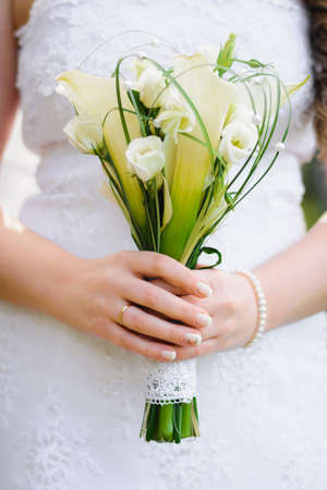 wedding flower bouquet in the hands of the brideの写真素材