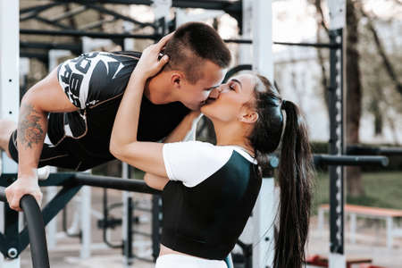 couple in love train together on the horizontal bars and play sportsの写真素材