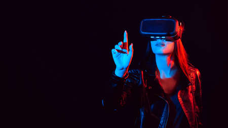 girl in 3D virtual reality glasses touches the projection screen with her fingerの写真素材
