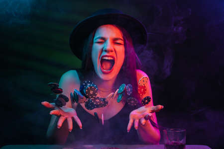 Playing poker and gambling in casino. Emotional girl throws up chips