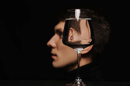 portrait of a man in profile through a glass of waterの写真素材