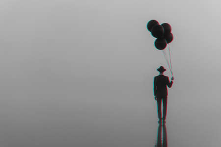 surreal creative portrait of a man in a suit with a hat with balloons in his hand on the waterの写真素材