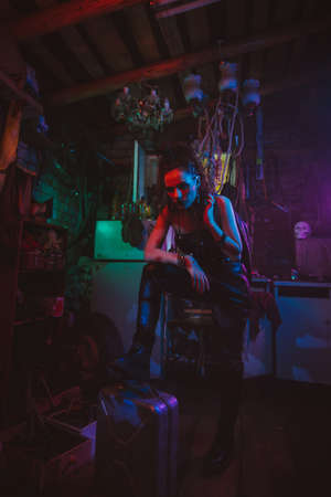 Cyberpunk girl in a post-apocalyptic futuristic style in a garageの写真素材