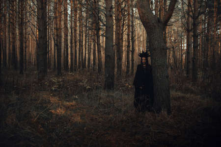 dark portrait of a frightening witch in black costumeの写真素材