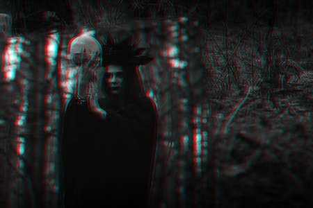 reflection in the mirror of an evil scary witch with a dead mans skull performing mystical occult ritualsの写真素材