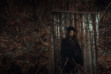 blurred mystical silhouette of an evil terrible witch in a mirror