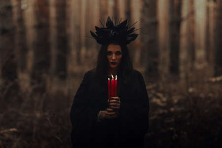 black terrible witch holds candles in her handsの写真素材