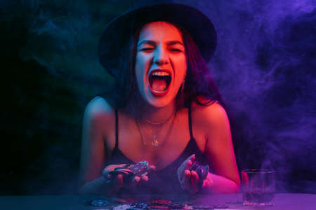 Playing poker and gambling in casino. Emotional girl throws up chipsの写真素材