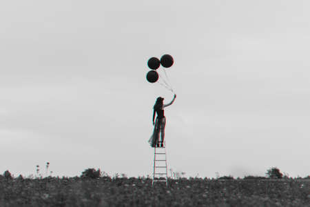surreal photo of a lonely girl on the stairs with balloons