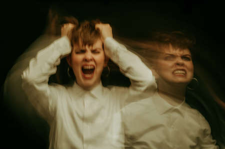 woman is psychopath with schizophrenia and mental disorders. Abstract blurry portrait of a girl with psychosis and panic attacksの写真素材