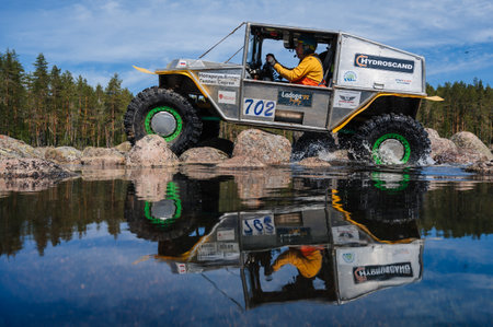 REPUBLIC OF KARELIA, RUSSIA - CIRCA JUNE, 2022: Off-road tournament Ladoga Trophy 2022 around Lake Ladoga. 4x4 jeep SUV rides on rocks near the lake waterのeditorial素材