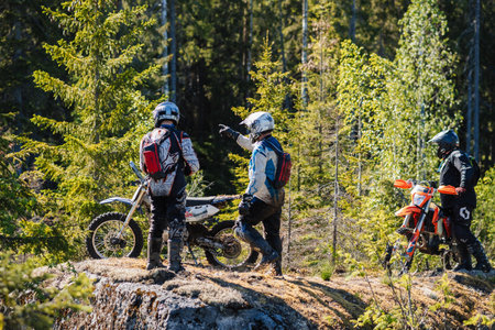 REPUBLIC OF KARELIA, RUSSIA - CIRCA JUNE, 2022: Off-road tournament Ladoga Trophy 2022 in Karelia. Motorcycle racers with sports motorcycles are looking for a road in the forestのeditorial素材