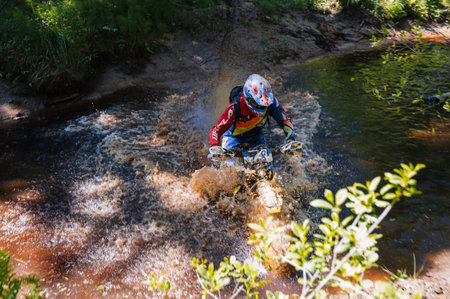 REPUBLIC OF KARELIA, RUSSIA - CIRCA JUNE, 2022: Off-road tournament Ladoga Trophy 2022 in Karelia. Motorcycle racer on an enduro sports motorcycle overcomes a river in a ford during a raceのeditorial素材