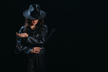 Sexy female dominant mistress with a whip flogger and handcuffs for BDSM sex with submission and...