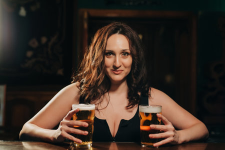 sexy woman with big breasts with two glasses of lager beer in hand at barの写真素材