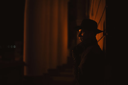 male mafia detective in a hat and raincoat at nightの写真素材
