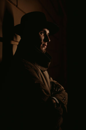 man mafia detective in a hat and raincoat in a night city