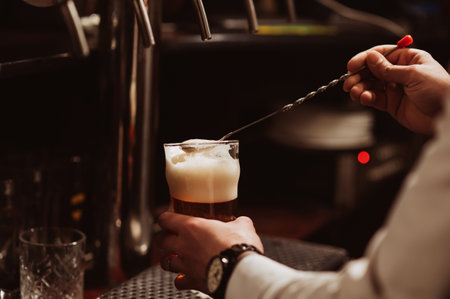 bartender removes the foam from the beer from the glass in the bar