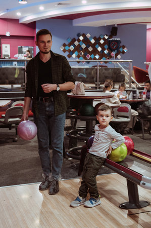 dad and son play bowling at clubの写真素材