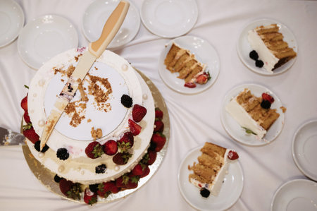 festive wedding cake cut into pieces with a knife
