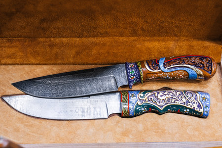 two traditional oriental Uzbek chust knives made of Damascus steel in a wooden gift box in Uzbekistanの写真素材