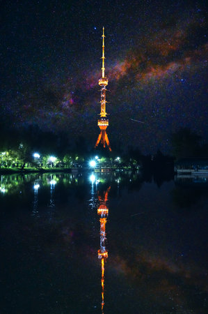 landmark television TV tower illuminated at night in Tashkent in Uzbekistan with a reflection in...