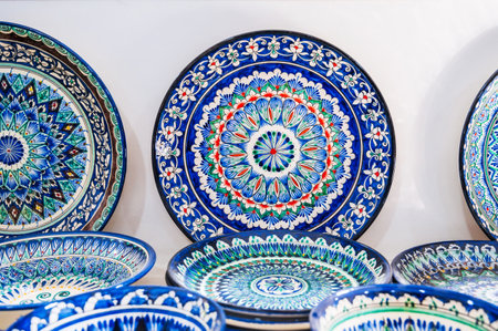 Arabic Uzbek handmade ceramic plates with hand-painted with a traditional East Asian colorful pattern in a pottery workshop in Uzbekistanの写真素材