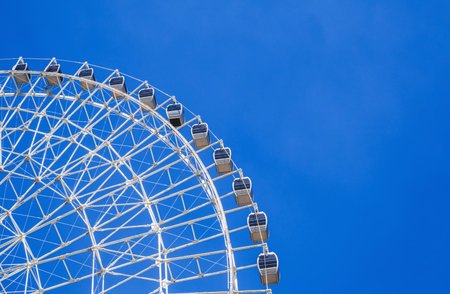 white big Ferris wheel on background clear blue sky in the amusement park at fair in summer with...