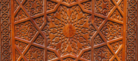 Arabic Uzbek Islamic patterns arabesque ornament on brown wooden carved door in Uzbekistan close upの写真素材